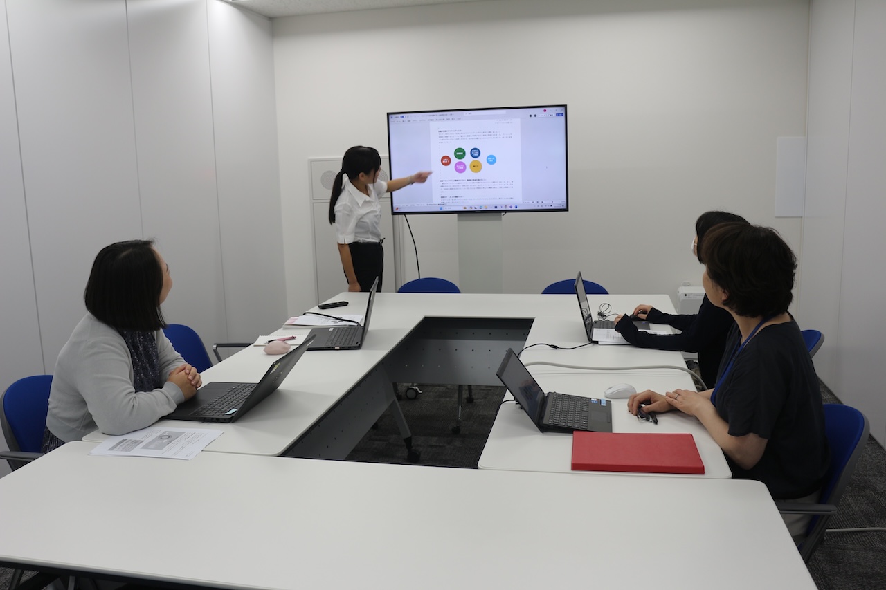 写真:会議室で4人の女性社員が会議をしている