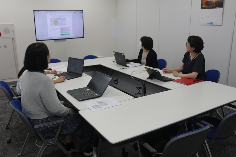 写真:スライドを見ながら話し合う社員の姿